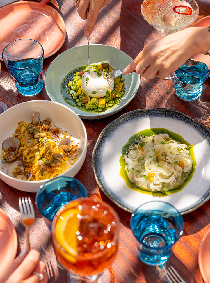 Three different dishes on a table at Maybourne La Plage with tableware next to it.